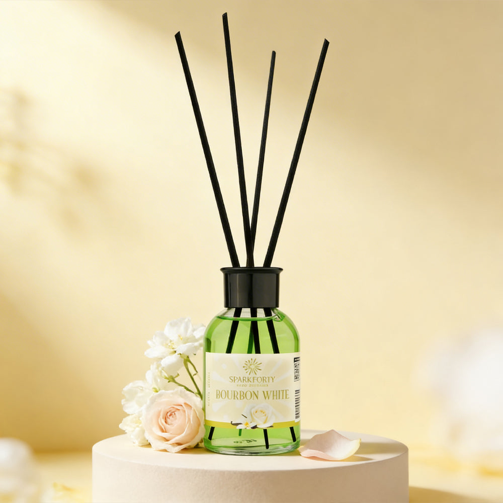 Sparkforty Bourbon White premium reed diffuser with black reeds in a green glass bottle, displayed with white and pink roses in an elegant home décor setting.