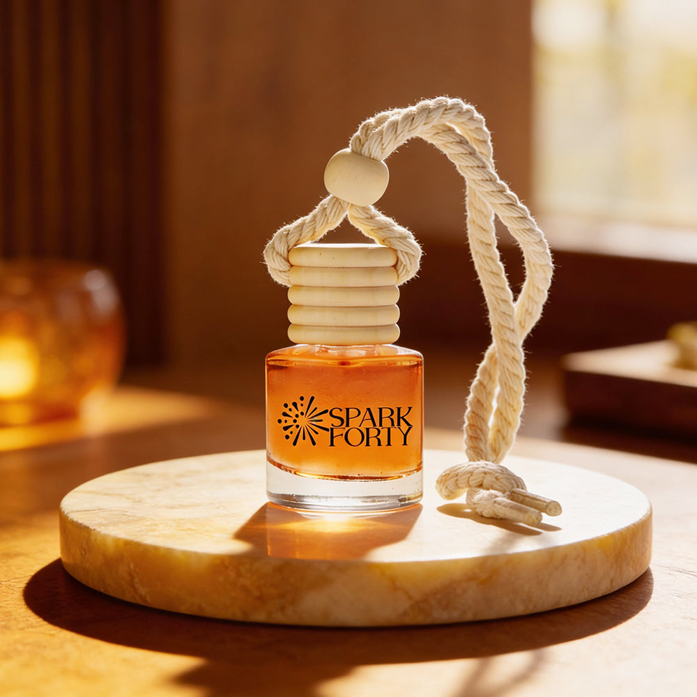 Sparkforty Sandal Amber car air freshener displayed on a marble pedestal, featuring a premium glass bottle with a wooden diffuser cap and cotton rope in a warm wood-inspired setting for a luxurious long-lasting car fragrance.